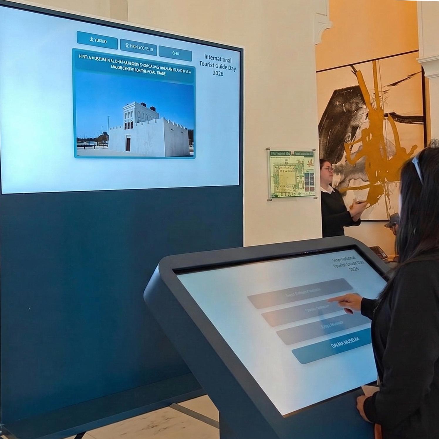 Multi-screen interactive UAE landmark guessing game display with custom branded interface for immersive event activation and digital tourism engagement.